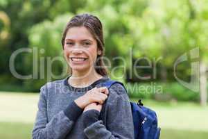 Young smiling girl standing upright in a park