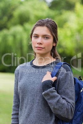 Young relaxed girl looking straight at the camera while standing