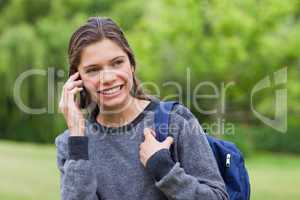 Young smiling girl looking away while talking on the phone