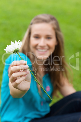 White flower held by a young smiling woman