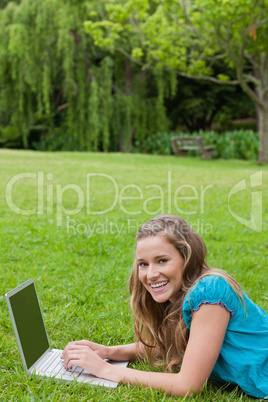 Young girl laughing while typing on her laptop