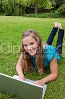 Smiling teenage girl looking at the camera while lying on the gr