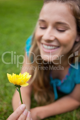 Yellow flower held by a smiling teenage girl