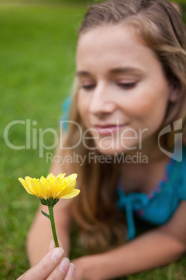 Yellow flower held by an attractive young woman