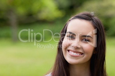 Young smiling woman looking at the camera while standing up in a