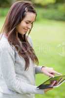 Young smiling girl using her tablet computer while standing in a
