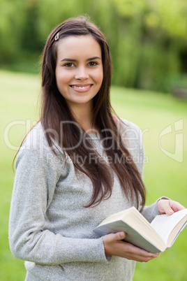 Young smiling woman standing up while looking at the camera and