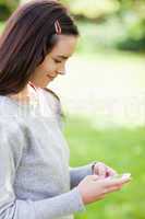 Relaxed young woman sending a text while standing in the country