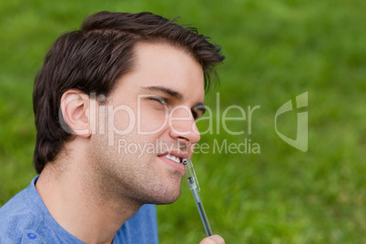 Thoughtful young man looking towards the side while holding his Thoughtful young man looking towards the side while holding his