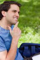 Young smiling man placing his finger on his chin