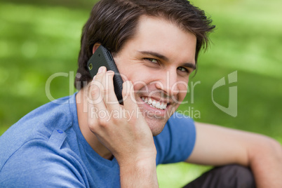 Smiling young man looking straight at the camera while talking o