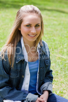 Young attractive girl sitting on the grass in a park