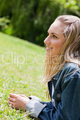 Young smiling girl lying on the grass in the countryside
