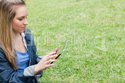 Young serious girl using her tablet pc in the contryside