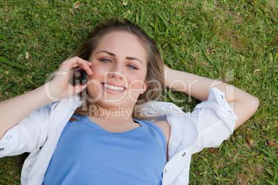 Young smiling blonde girl lying on her back while looking up