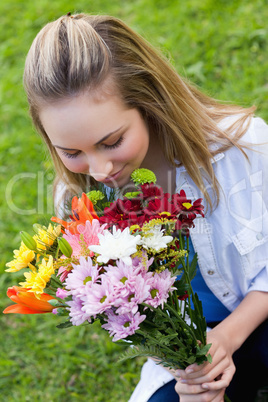 Young attractive girl smelling a bunch of flower