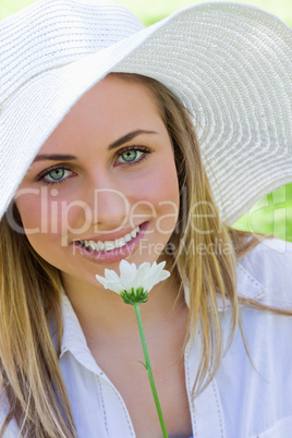 Young attractive blonde girl wearing a white hat while holding a