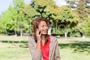 Young woman talking on the phone while looking toward the side i