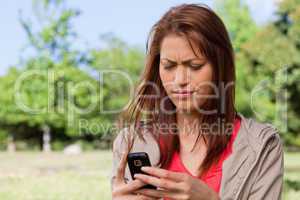 Young woman with a concerned expression reading a text message