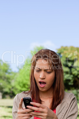 Woman with a shocked while reading a text message
