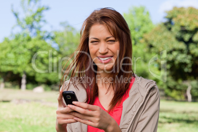 Young woman smiling happily while holding a phone