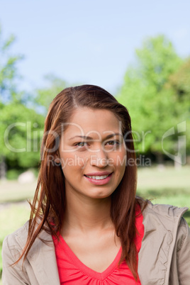 Woman smiling as she looks straight in front of her in a park