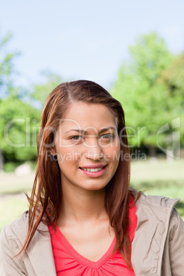 Young woman smiling as she looks into the distance while in a br