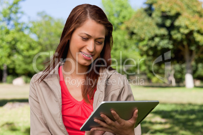 Woman leaning her head to the side while smiling and using a tab