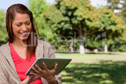 Young woman smiling enthusiastically while using a tablet