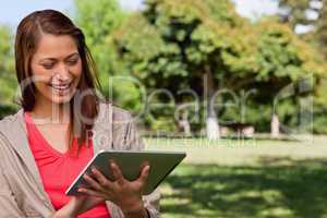 Young woman smiling enthusiastically while using a tablet