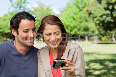 Woman and her friend looking at pictures on a camera