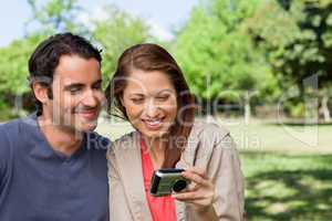 Woman and her friend looking at pictures on a camera