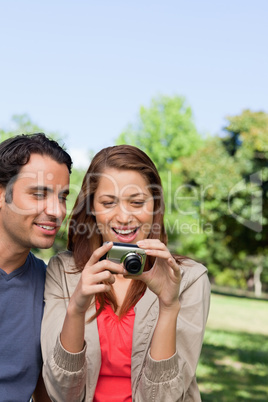 Two friends looking at the photo collection in her camera