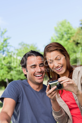 Two friends smiling happily as the look at the photo collection