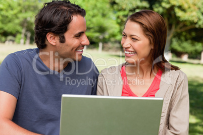 Two friends smiling as they look at each other while holding a t