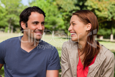 Man is grinning while he watches his friend who is laughing