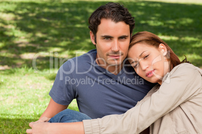 Man with his friend who is resting her head on his shoulder
