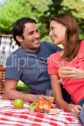 Two friends looking at each other while they hold glasses as the