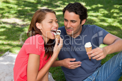 Woman eating ice cream while sitting with her friend