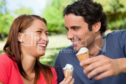 Two friends laughing while holding ice cream