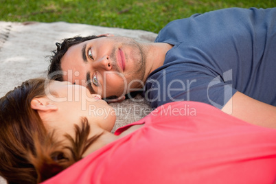 Man looking into his friends eyes while lying on a quilt