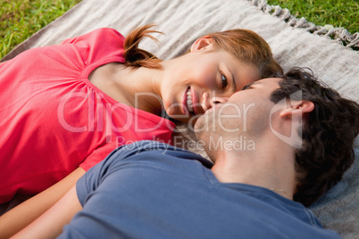 Woman looking into her friends eyes while lying on a quilt