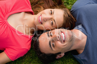 Two friends smiling while lying head to shoulder