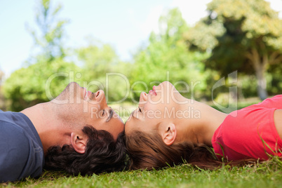 Two friends with their eyes closed while lying head to head