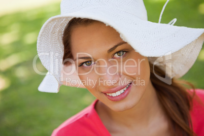 Woman smiling while wearing a white hat