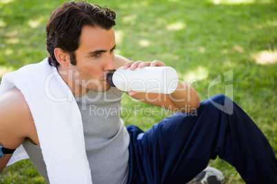 Man looking ahead while drinking from a sports bottle