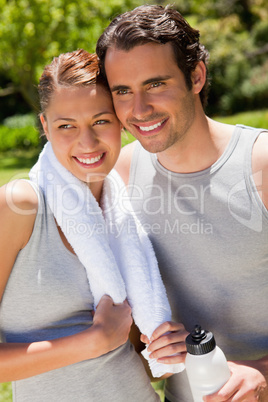 Man holding a sports bottle smiling with a woman