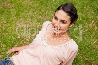 Woman smiling as she lies down on the grass