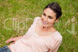 Woman smiling as she lies down on the grass