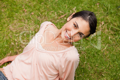 Smiling woman looking upwards while lying down
